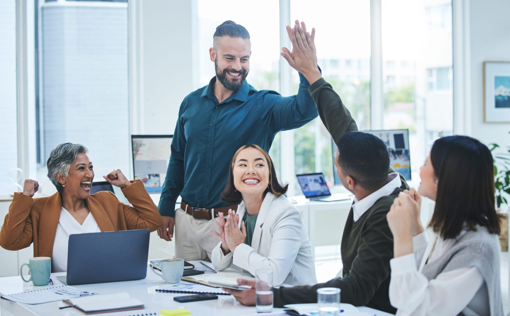 Team celebrating success with high fives.